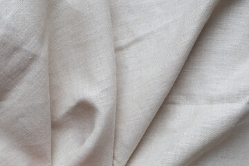 Textured folds of linen fabric in beige color