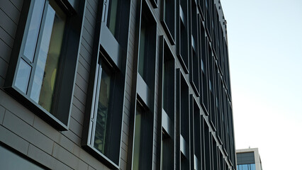 Exterior of modern dark house object. Architectural detail of a skyscraper, close-up on the windows. Real estate, residential apartments and offices. Living apartments or office building architecture.