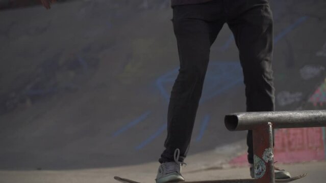Man skater jumps and make 50-50 fifty fifty grind trick. Slow motion video.