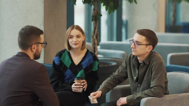 Male consultant receives cash from young couple and shakes hands