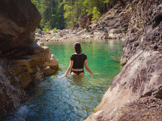Turkey travel, mediterranean area on a warm summer day. Young woman in swimsuit have fun in mountain river. Concept of living open air, Travel , active lifestyle, summer vacation.