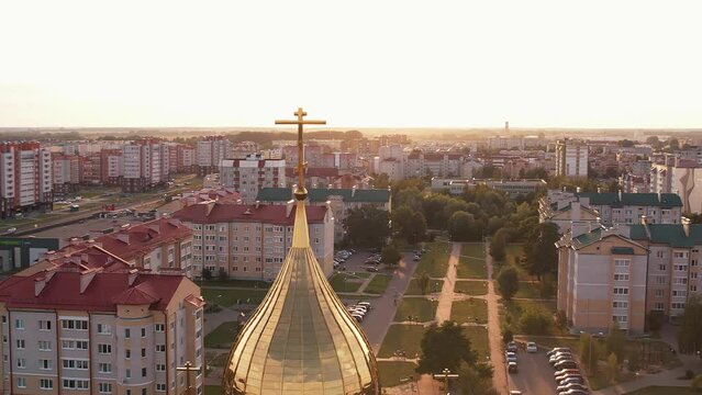 Aerial view of beautiful orthodox church with crosses on golden domes and new microdistrict with infrastructure