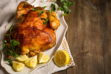 A whole baked chicken with lemon on a plate