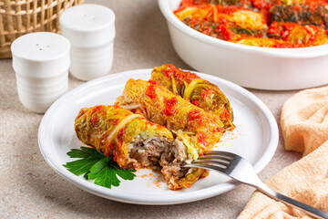 Baked savoy cabbage rolls stuffed with ground beef meat and rice in a tomato sauce.
