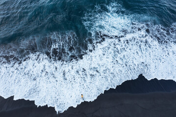 Drohnenaufnahme,Mann steht in der Meeresbrandung am Strand von Praia de Santa Barbara,Ribeira Grande,Insel Sao Miguel, Azoren, Portugal,
