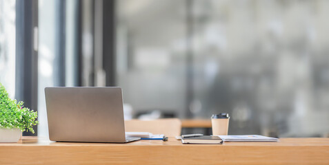 Minimal background image of inviting empty workplace laptop with white desk and succulent plant in foreground, copy space