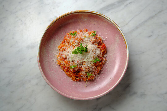 Cherry tomato sugo risoni in a pink bowl