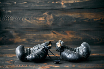 Old boxing gloves on wooden background