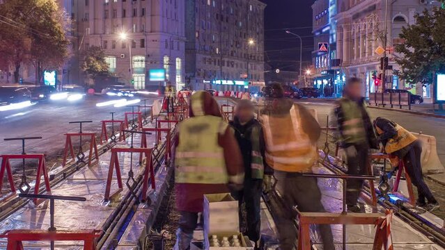 Tram rails at the stage of their installation and integration into concrete plates on the road night timelapse. Filling by liquid resin for reduction of vibration and noice. The process of