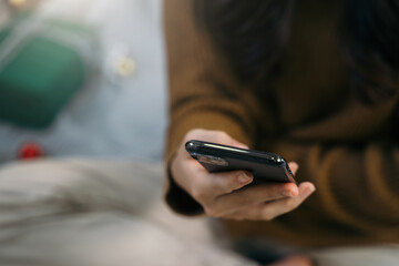 woman's hand smartphone on background of christmas