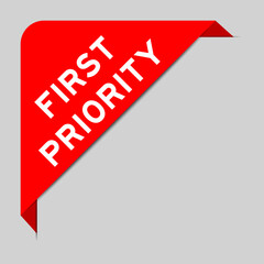 Red color of corner label banner with word first priority on gray background