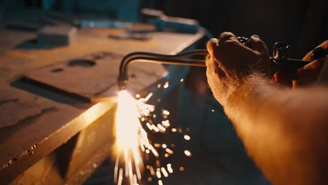 A man cuts metal with a gas torch.