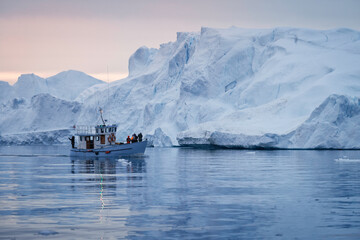 Barco navegando entre grandes icebergs.