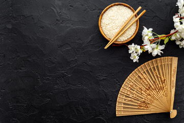 Bowl of rice and asian fan with cherry blossom branch. Asian concept