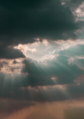 The sun's rays passing through the clouds and shining form an interesting light pattern against the sky. Space for text, Selective focus.