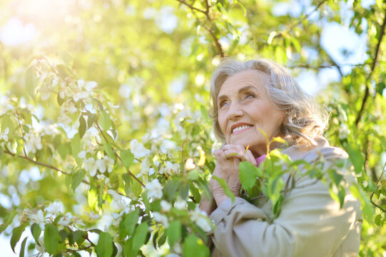Happy smiling old woman posing in park outdoors