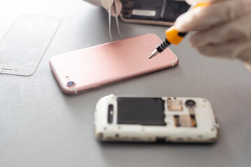 Technician repairing mobile phone at table, closeup