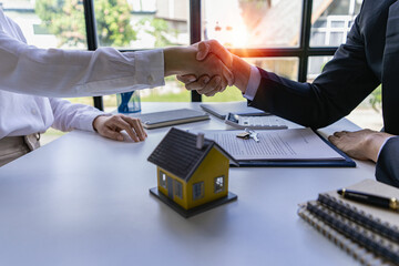Buyers and real estate agents agree to trade in handshake to rent or buy a home after signing a contract. Businessman congratulates buyer after agreeing to insure and buy house project, insurance - obrazy, fototapety, plakaty