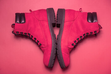 Viva magenta color boots on colored background. Trendy color 2023