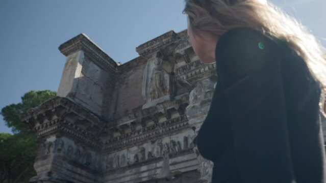 Female Tourist Outside The Colonnacce Of The Forum Of Nerva In Rome, Italy. low angle, slow motion