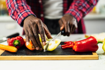 Attractive man cooking in modern kitchen. Handsome chef preparing salad.