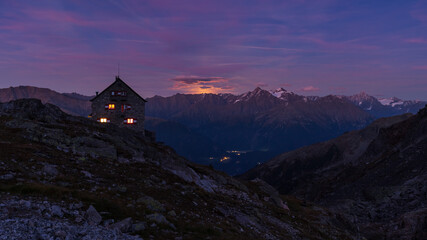 Full moonrising above alpine ridge behind the hut