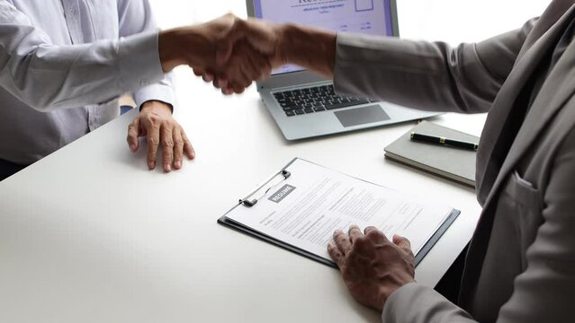 Job applicant submits resume during job interview with company manager.