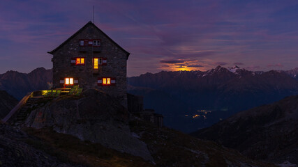 Full moonrising above alpine ridge behind the hut