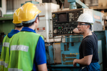 Caucasian supervisor engineer is on the job training apprentices To Use Computerized Lathe operation of machine to asian team controls machine to produce a complete quality product in industry factory