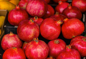 Fototapeta na wymiar close up pomegranates on counter in market. textured background of natural fruits