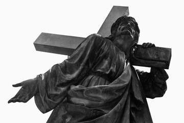 Ancient stone statue of Jesus Christ with cross. Black and white image.