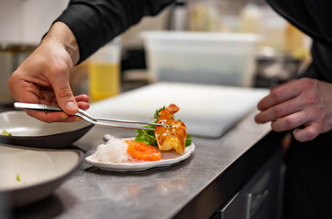 chef cooking slice salmon fish and shrimp with salad on kitchen