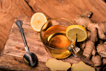 Lemon and ginger infused water on rustic wooden table.
