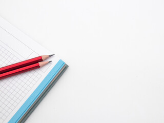 red pencil on notebook on white background, copy space area 