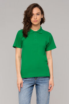 Green polo on a young woman in jeans, isolated, with copy space, mockup.