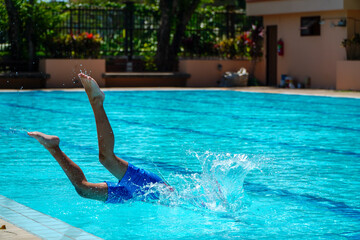 Asian children swimming in the racing pool - front crawl style with whole body in water