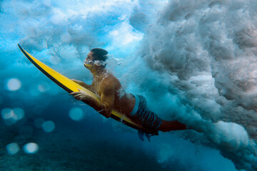 Underwater view male surfer in blue ocean wave, sunny day. - 553217457