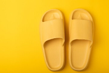 Bright rubber slippers on a yellow background. Summer slates. Indoor shoes. Place for text. FLAT LAY