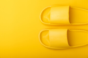 Bright rubber slippers on a yellow background. Summer slates. Indoor shoes. Place for text. FLAT LAY
