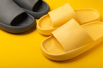 Bright rubber slippers on a yellow background. Summer slates. Indoor shoes. Place for text. FLAT LAY