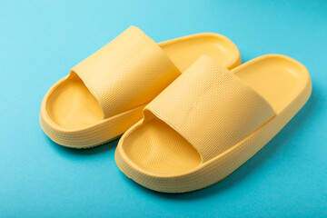 Bright rubber slippers on a blue background. Summer slates. Indoor shoes. Place for text. FLAT LAY