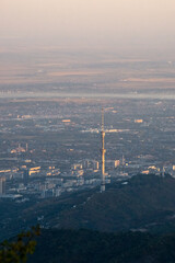 TV tower on the background of the city. a city at the foot of the mountains