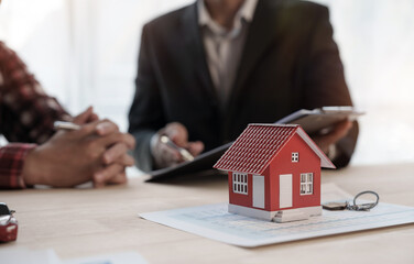 Reading a contract, Credit approver, businessman in male suit and house toy model mockup Home loan mortgage approval concept. After signing the contract