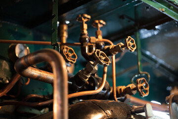 Old pipes and pressure valves on steam locomotive.