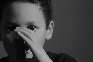 child with flu with inhaler respiratory puff on grey background with people stock photo