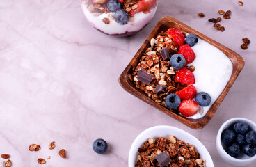 Yogurt with chocolate granola, strawberry and blueberry served in a bowl. Healthy breakfast