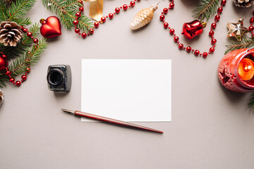 set of vintage dip pen, inkpot and blank paper sheet with envelope on white wooden table, Christmas...