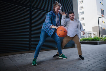 Man with down syndrome playing basketball outdoor with his friend. Concept of friendship and...