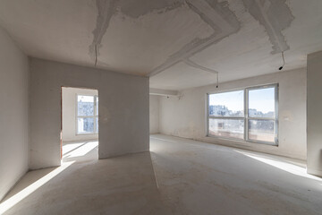 New empty room under construction. Plaster walls. New home. Concrete walls. Interior renovation.