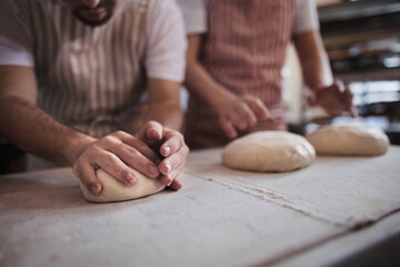 Obraz na płótnie Canvas Close-up of bakers preparing fresh pastries in bakery.